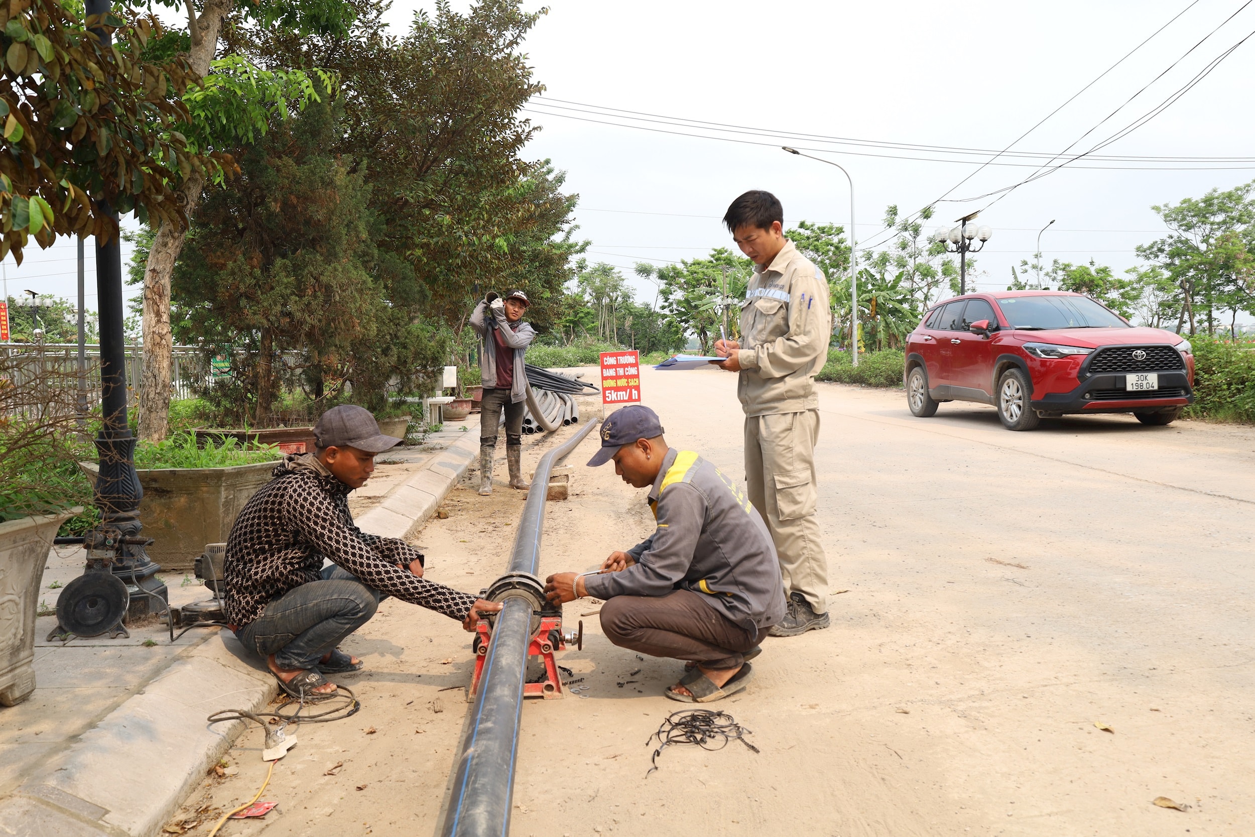 Công nhân Công ty cổ phần Nước sạch Hà Nam đang khẩn trương thi công tuyến ống dẫn nước sạch từ trục chính vào thôn Thượng (xã Phúc Sơn). Ảnh: Kim Nhuệ
