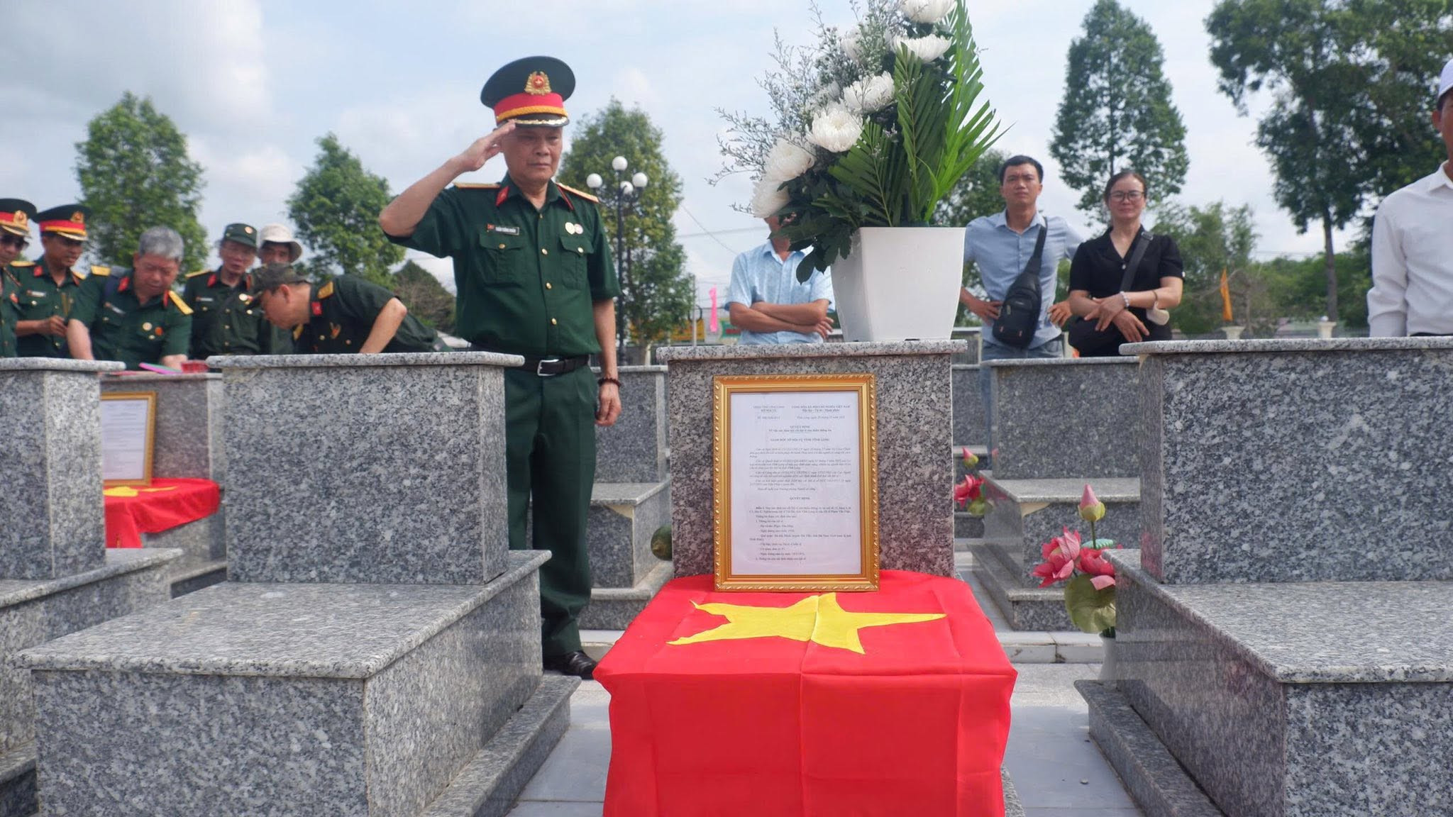 Đại tá, cựu chiến binh Trần Tường Huấn viếng mộ đồng đội - cácliệt sĩ Trung đoàn 1, Quân khu 9 được xác định danh tính trên bia mộ, tháng 3-2026. Ảnh: NVCC